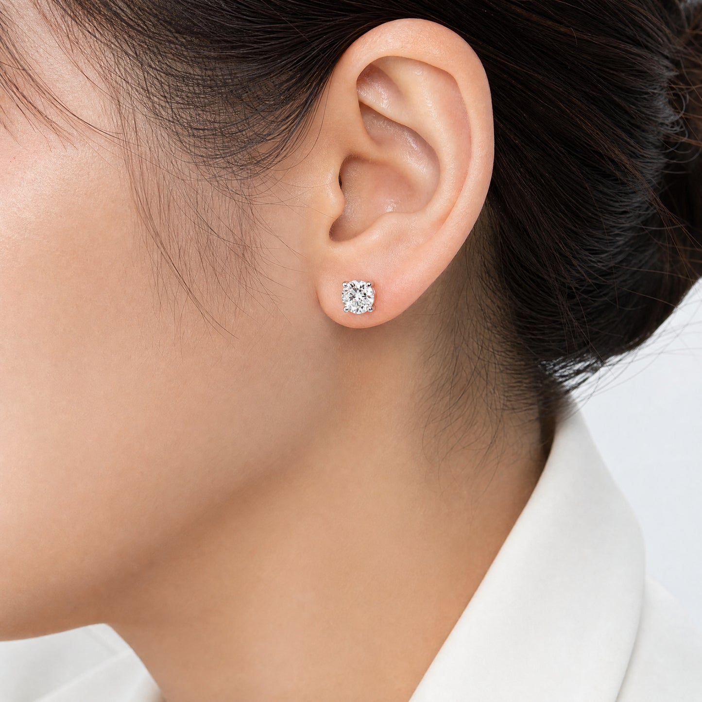 DECA0989W model shot round diamond solitaire stud earring worn on ear