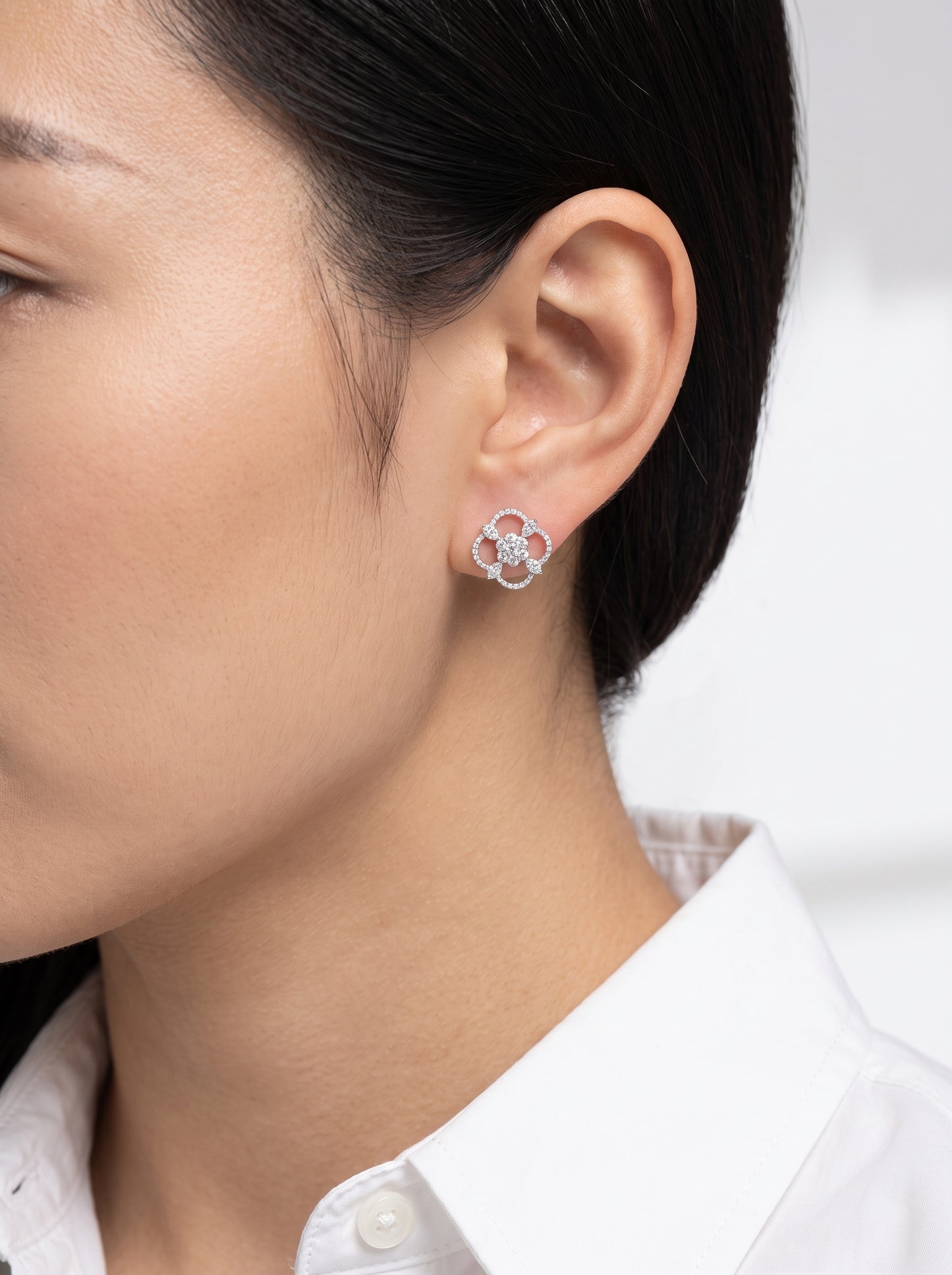 DEJ0249W model shot - large open quatrefoil diamond pave stud earring in 18K white gold worn on ear