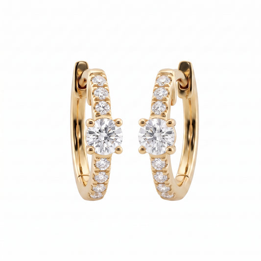 DERT0954 14K yellow gold hinged huggie hoop earrings with round brilliant centre stone and seven-diamond graduated row, angled view