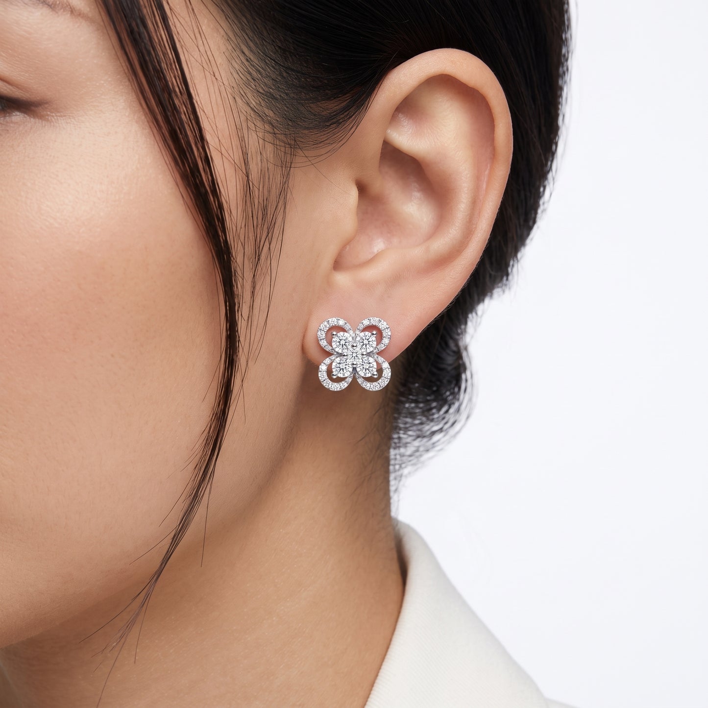 DERT0999W M-1 worn on the ear - 10mm four-petal pave flower stud sitting flush on the lobe, five-stone round brilliant centre cluster, 18K white gold