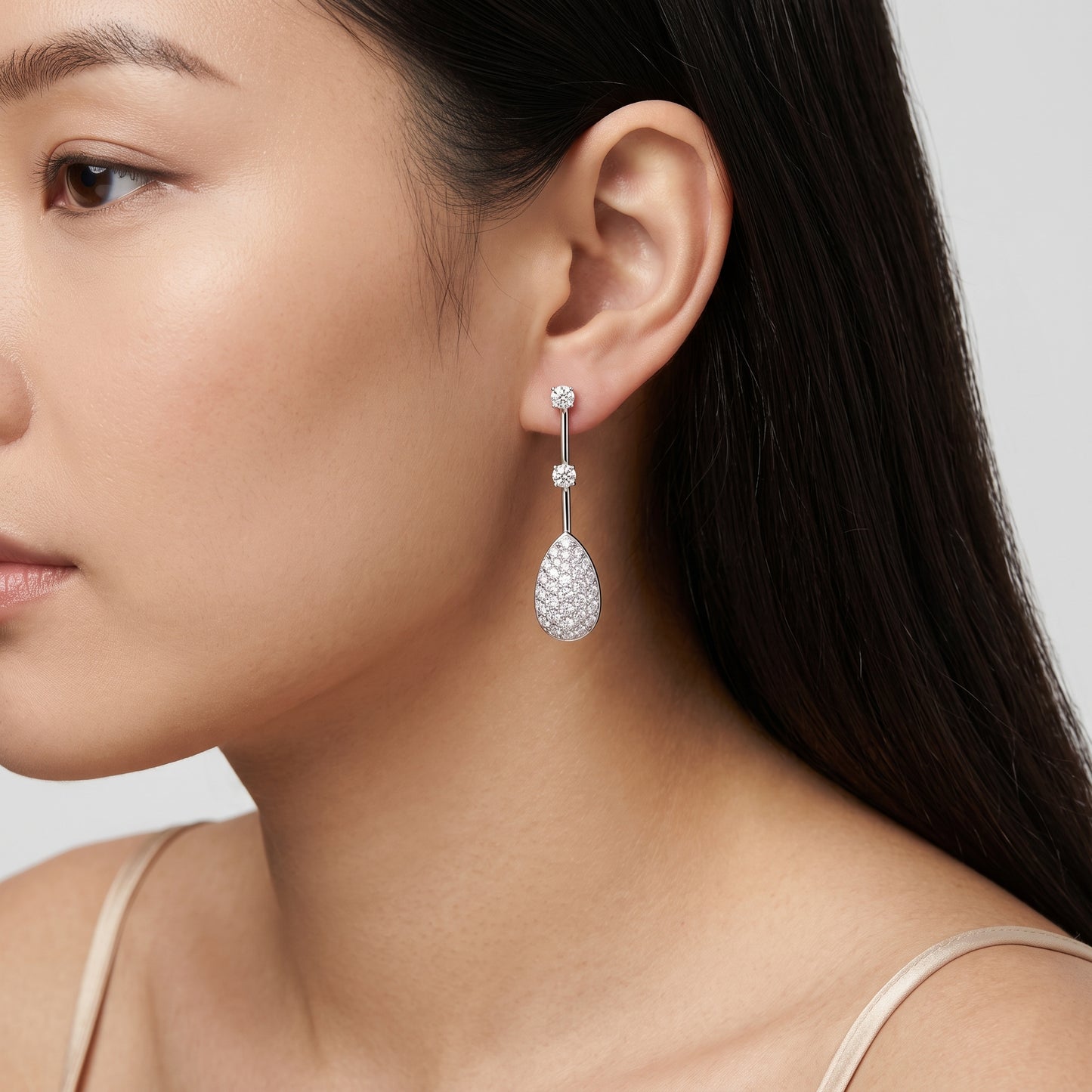 Model wearing 18K white gold pave pear drop diamond dangle earring