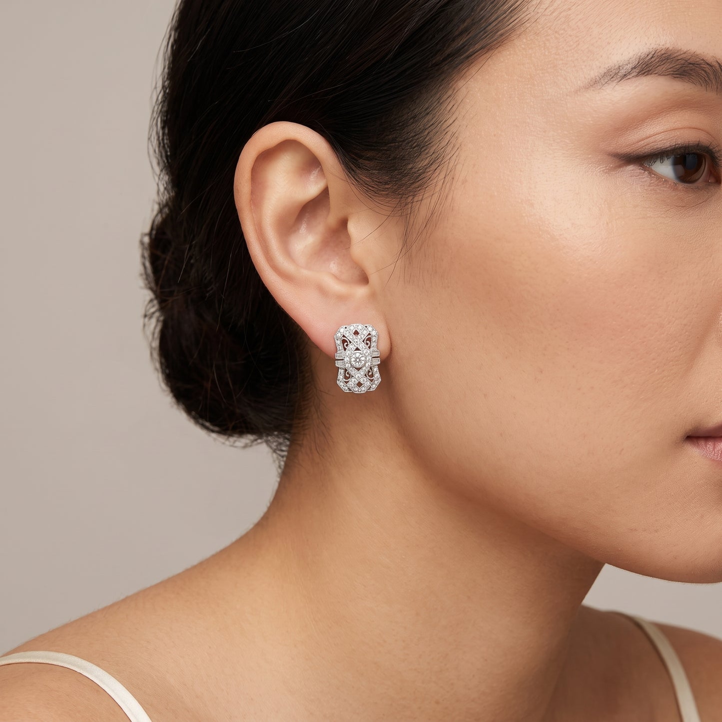 DECY0280W M-1 worn on the ear - Art Deco shield filigree clip earring sitting flush against the lobe, round brilliant centre diamond in a milgrain bezel collet, in 18K white gold