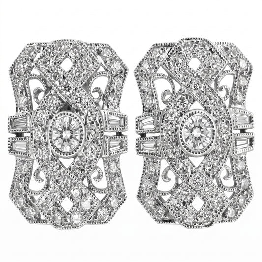 DECY0280W W-1 frontal pair - Art Deco shield-shaped filigree clip earrings with pinched concave sides and milgrain edging, a round brilliant centre diamond in a milgrain bezel collet, four tapered baguettes per earring set two either side of the waist, and pave round diamonds across pierced C-scroll filigree, in 18K white gold