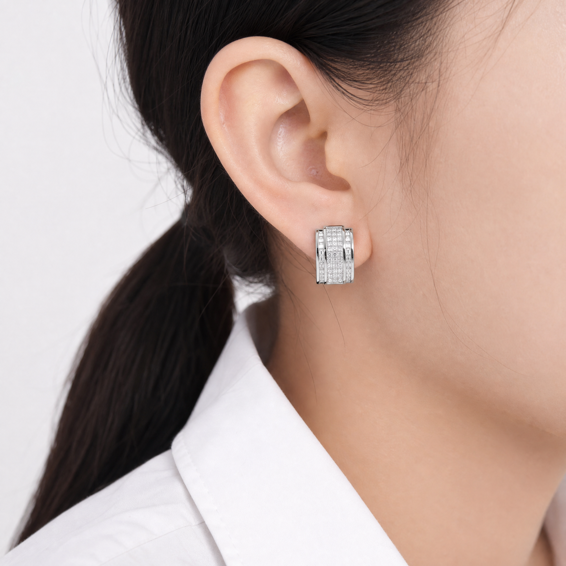DECY0794W-3 model shot - princess-cut and tapered baguette diamond multi-row channel clip earring worn on ear