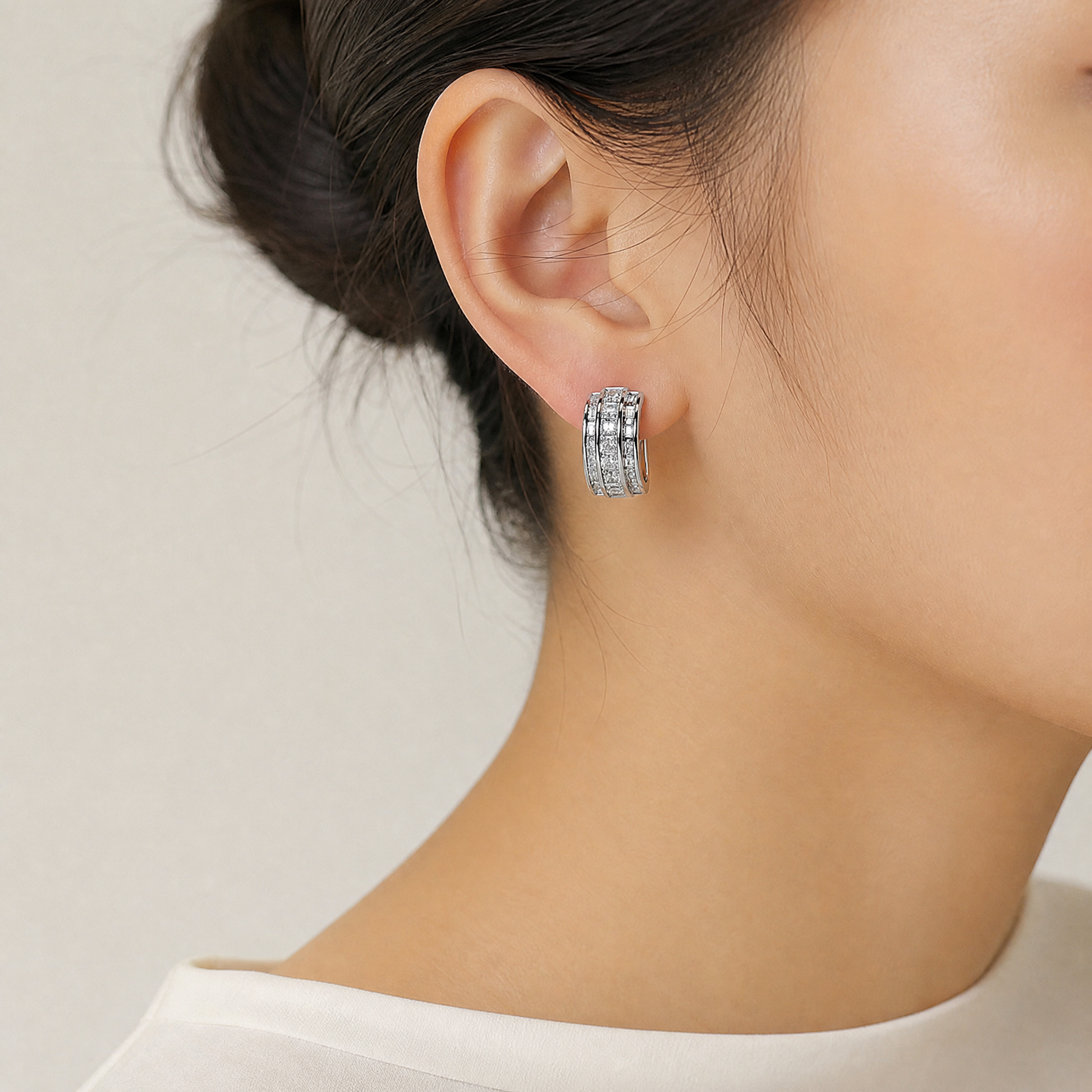 DECY0794W model shot - princess-cut and tapered baguette diamond channel-set half-hoop clip earring worn on ear