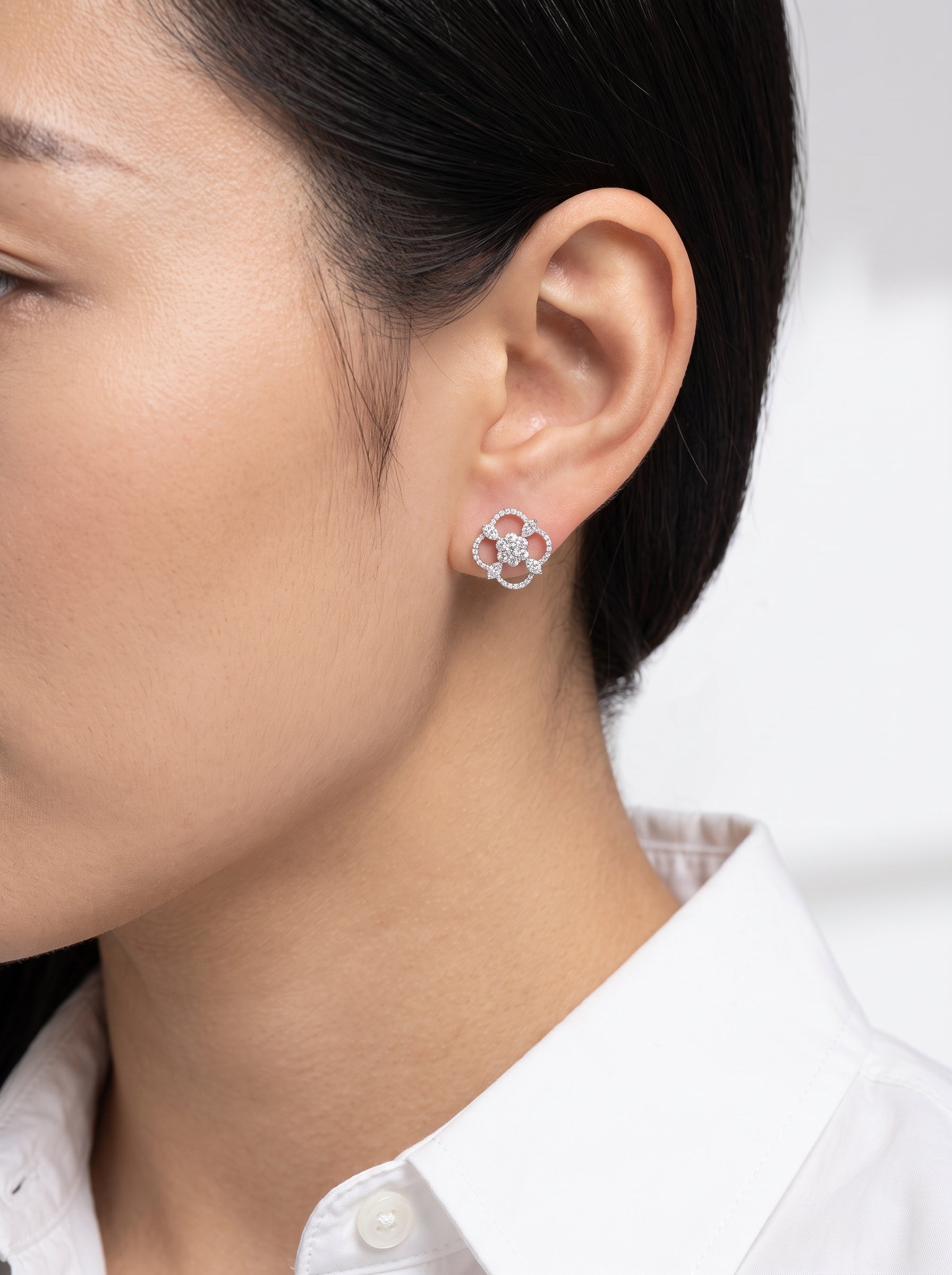 DEJ0249W model shot - large open quatrefoil diamond pave stud earring in 18K white gold worn on ear