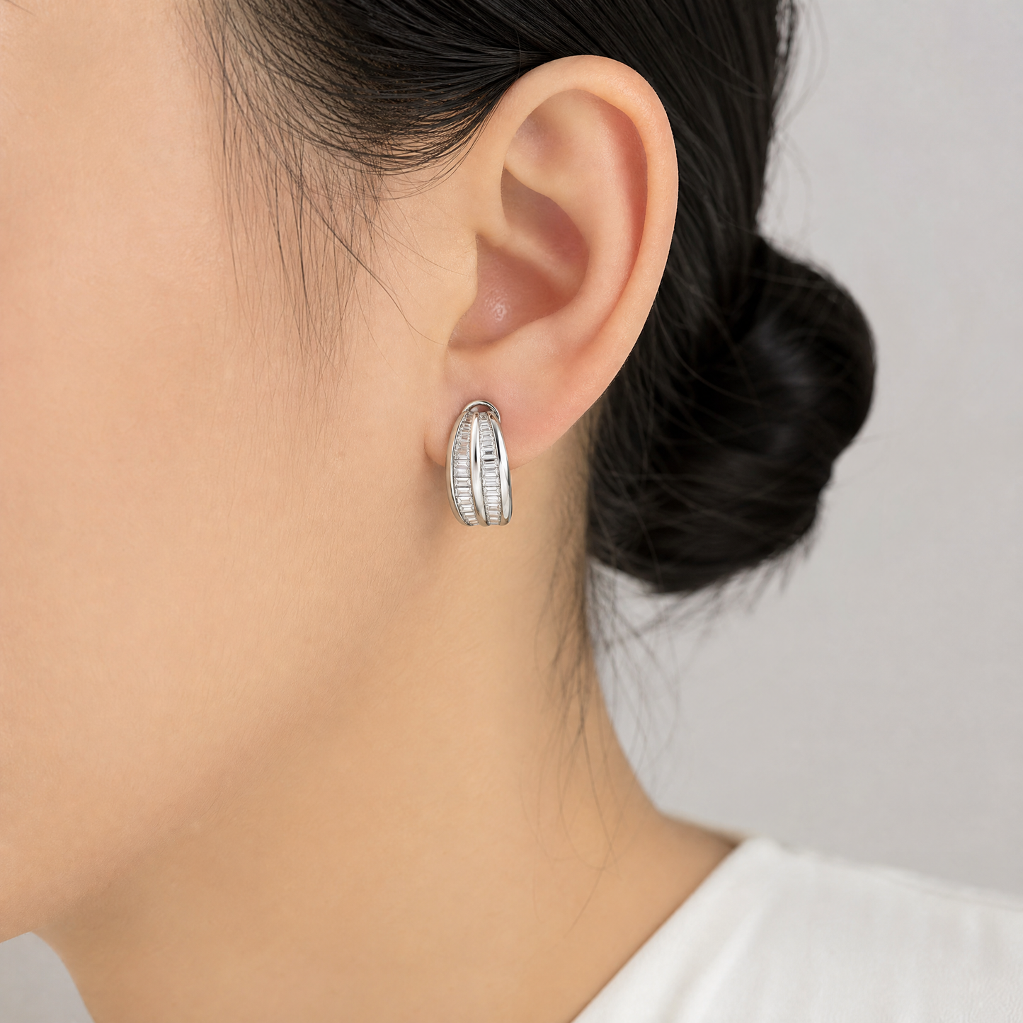 DERT0134W model shot - tapered baguette diamond three-row channel half-hoop clip earring worn on ear