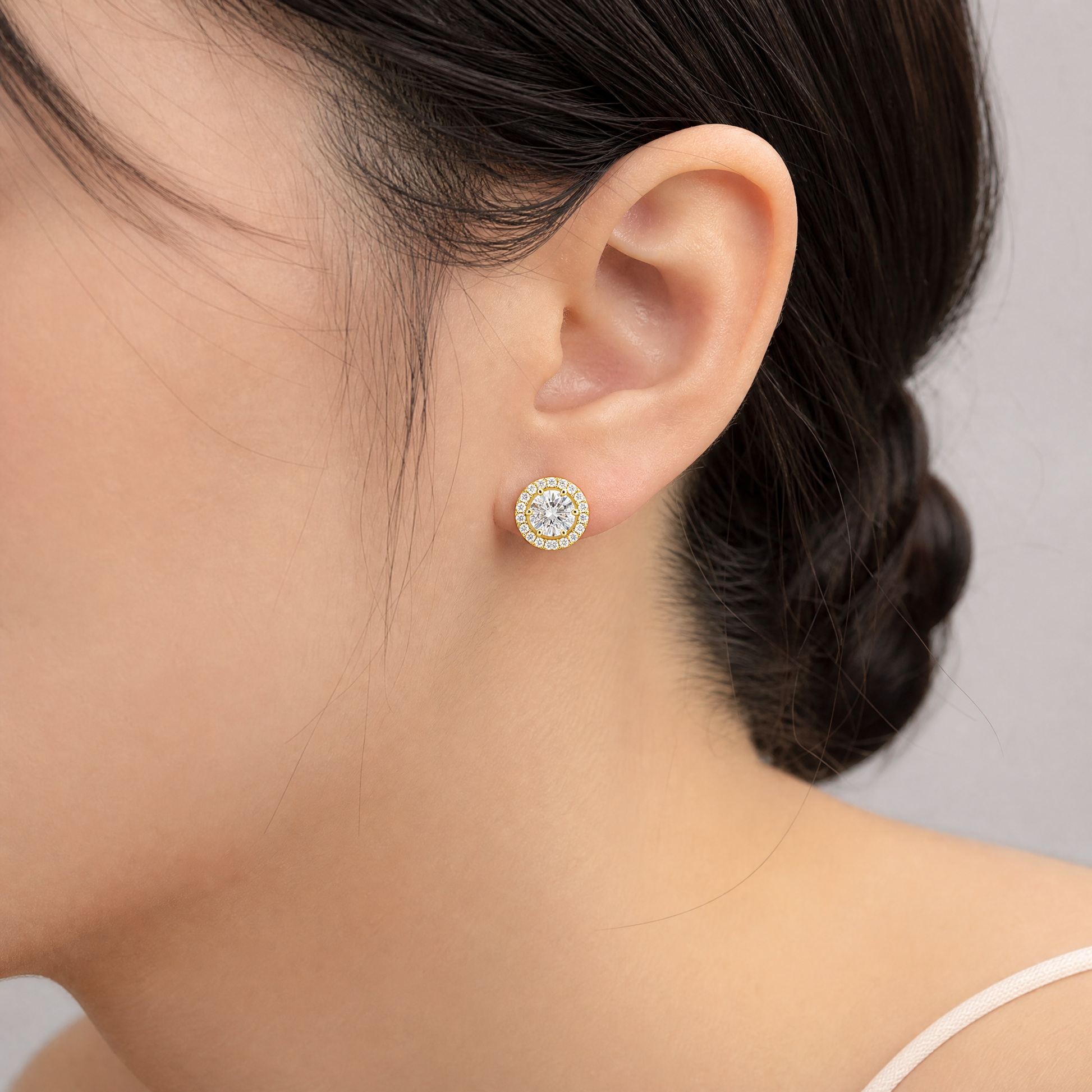 DERT0565 model shot - round diamond six-prong halo stud earring worn on ear