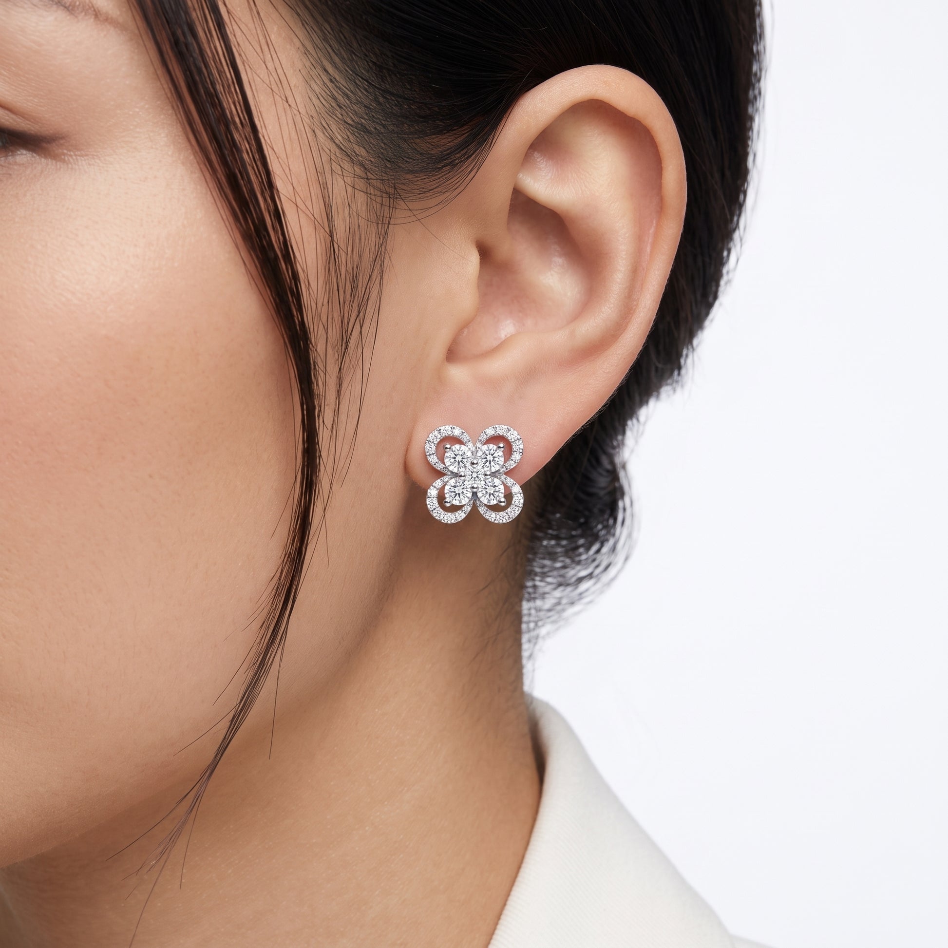 DERT0999W M-1 worn on the ear - 10mm four-petal pave flower stud sitting flush on the lobe, five-stone round brilliant centre cluster, 18K white gold