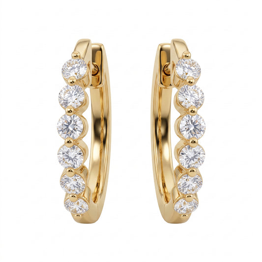 18k yellow gold oval huggie hoop earrings with six round brilliant diamonds each, white background