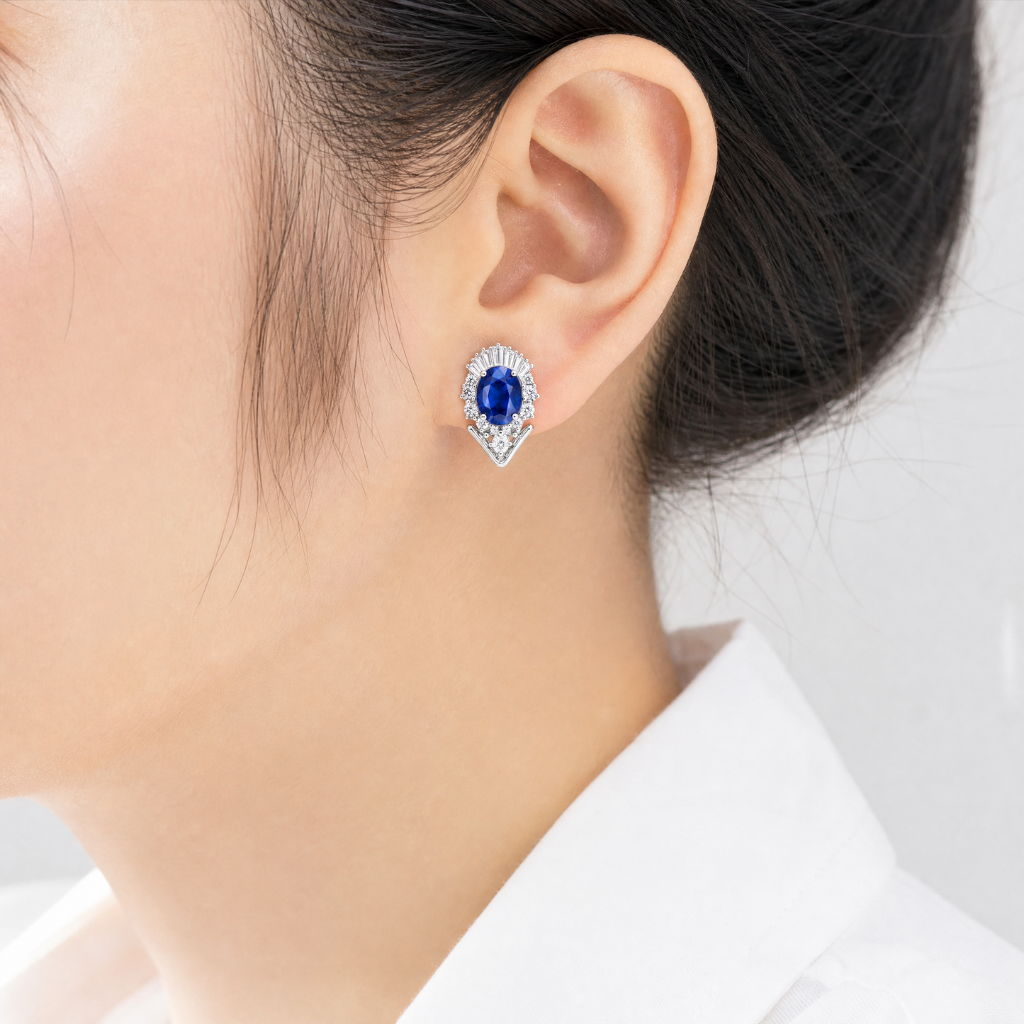 ME26811W model shot - oval blue sapphire and diamond ballerina clip earring worn on ear