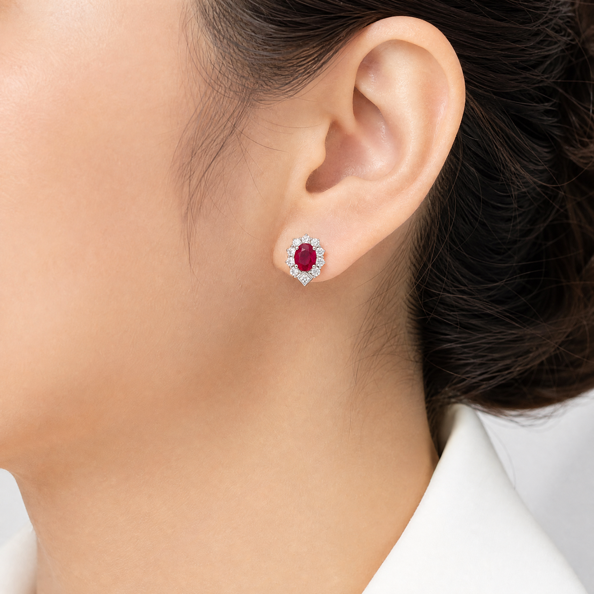 RETM0096W model shot - oval ruby and round diamond halo stud earring worn on ear