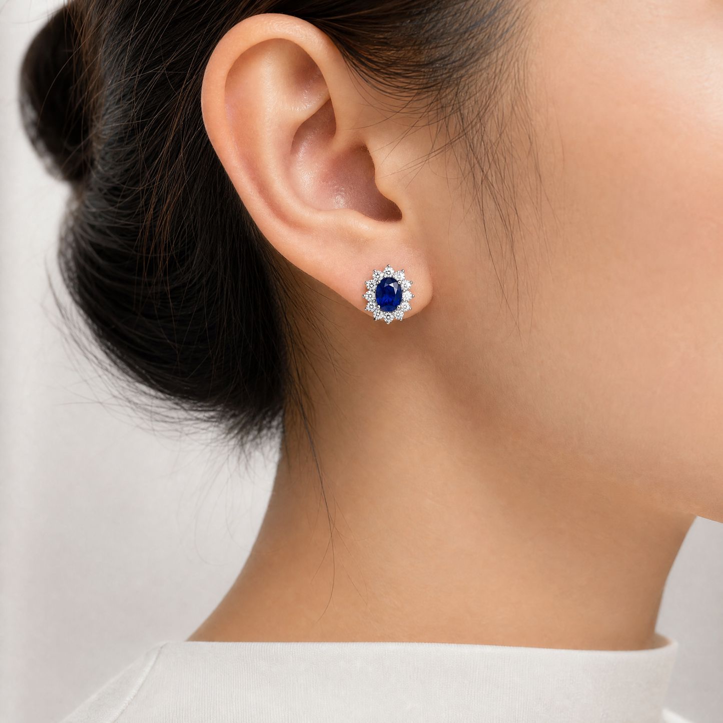 SECY0204W model shot - oval blue sapphire diamond cluster halo stud earring worn on ear