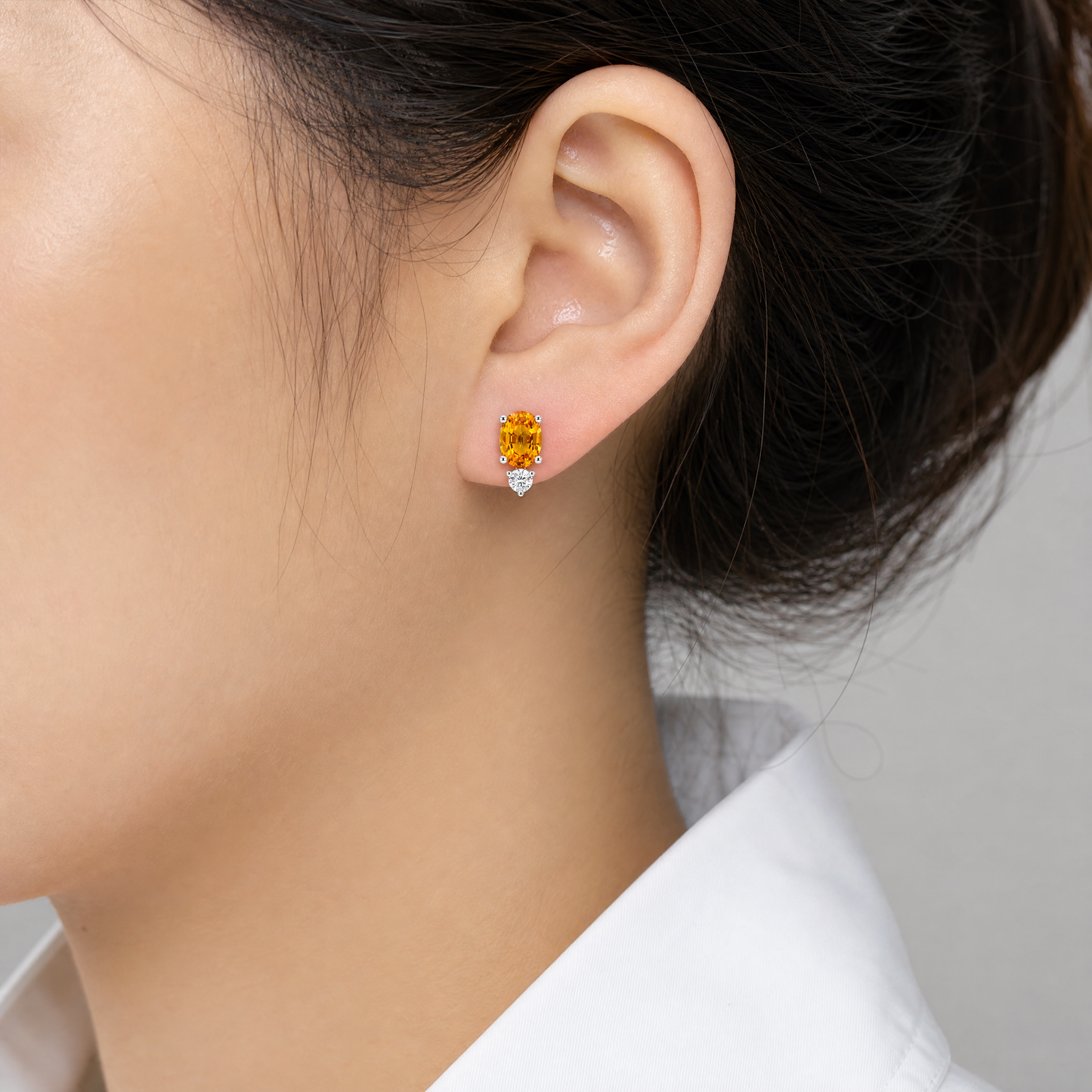 SECY1251AW-Y model shot - oval yellow sapphire and round diamond stud earring in 14K white gold worn on ear