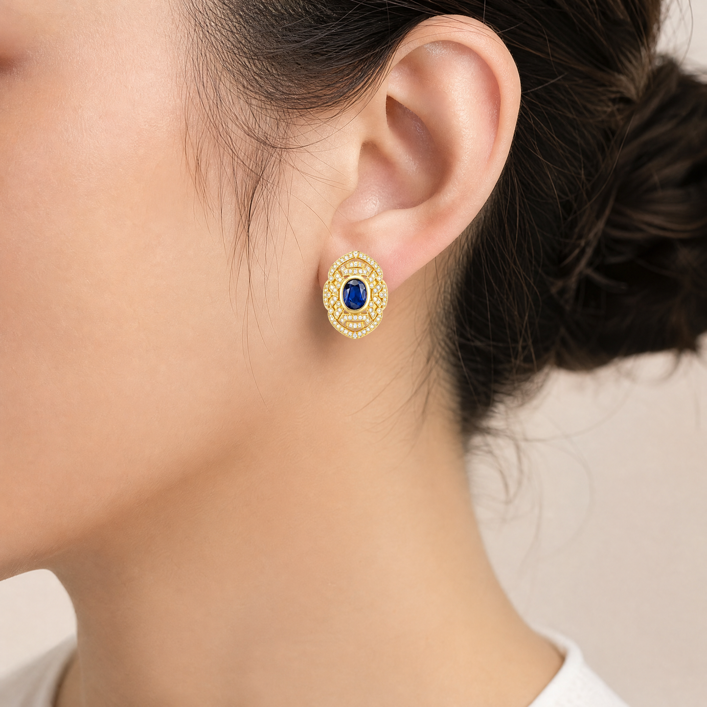 SED0017 model shot - oval blue sapphire and diamond milgrain openwork clip earring worn on ear