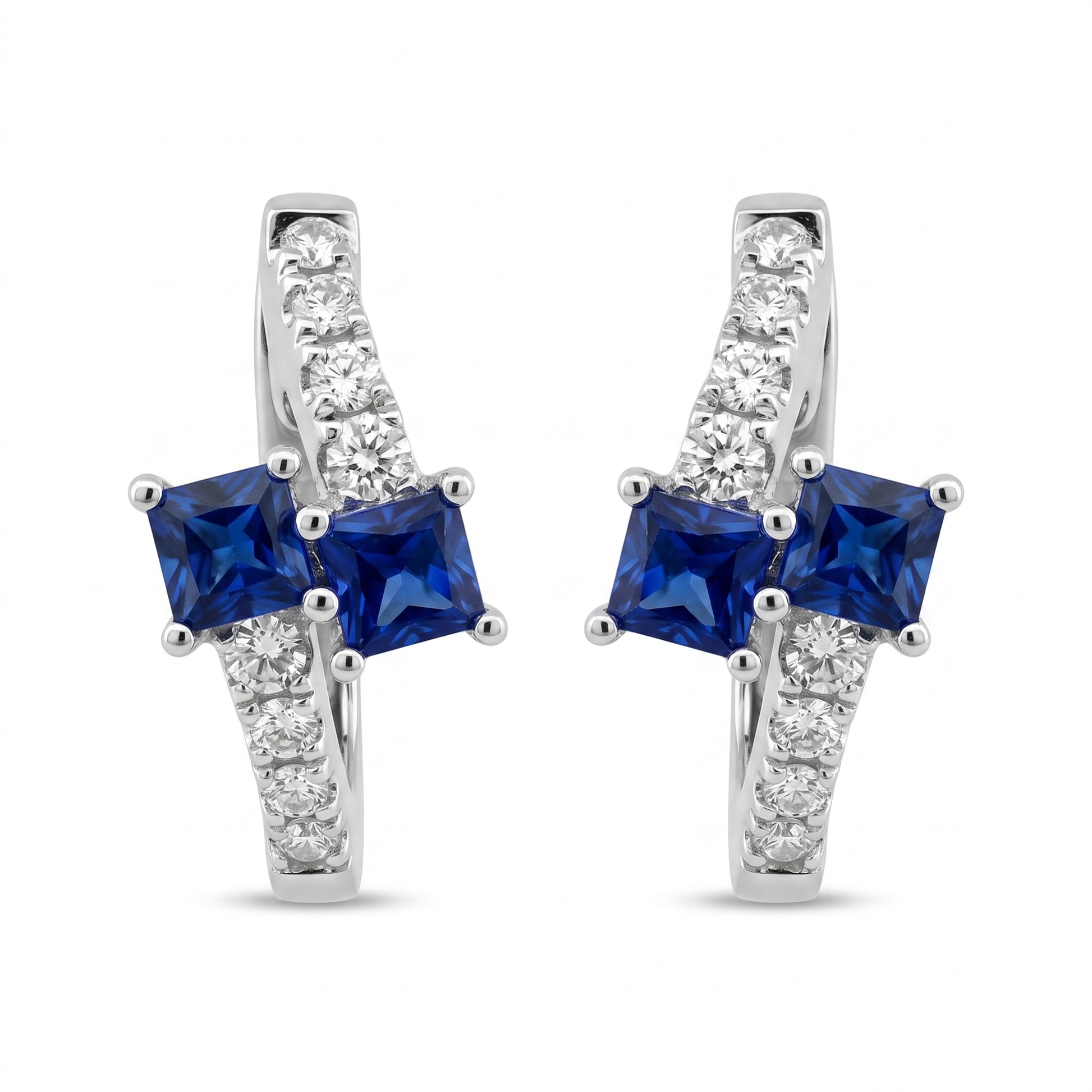 SEGS1005W 18K white gold oval huggie hoop earrings with two princess-cut blue sapphires and eight round diamonds each, white background