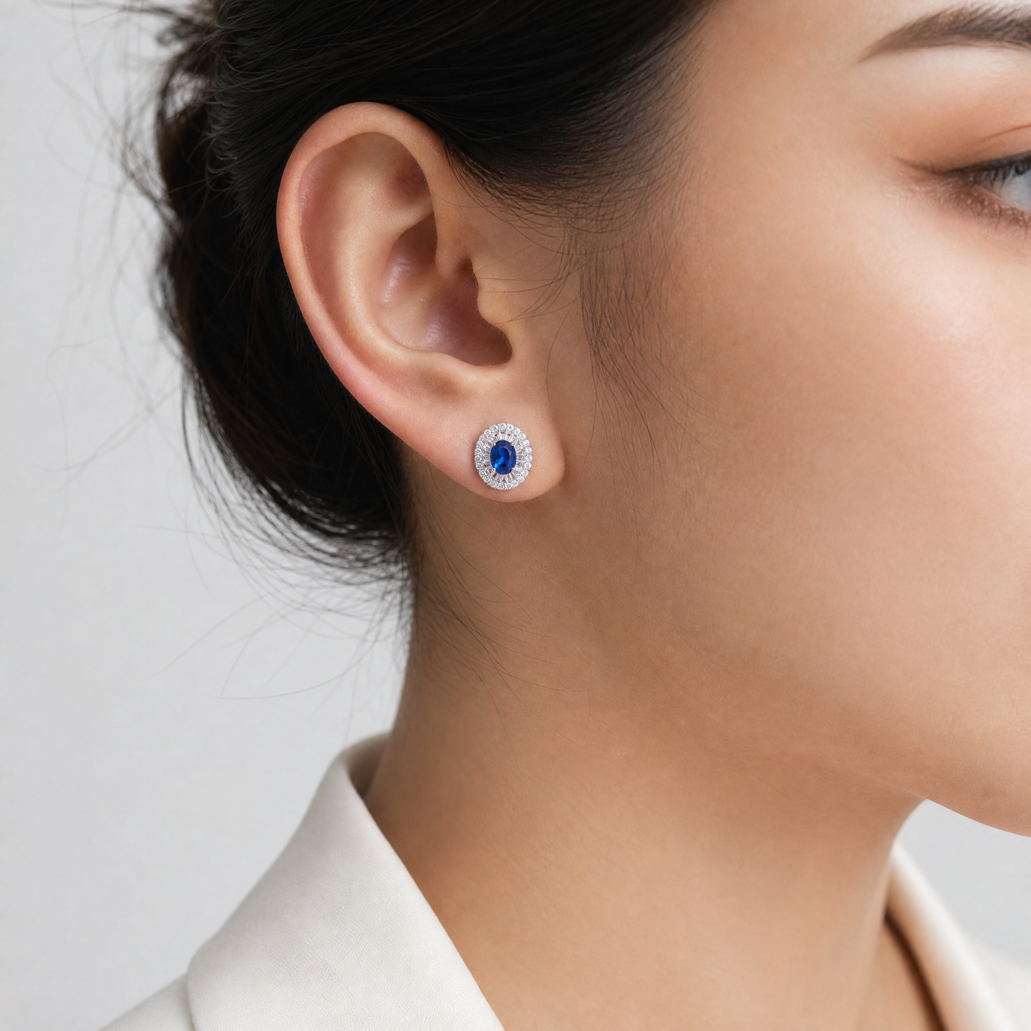 SERT0625W model shot - oval blue sapphire and diamond ballerina halo clip earring worn on ear