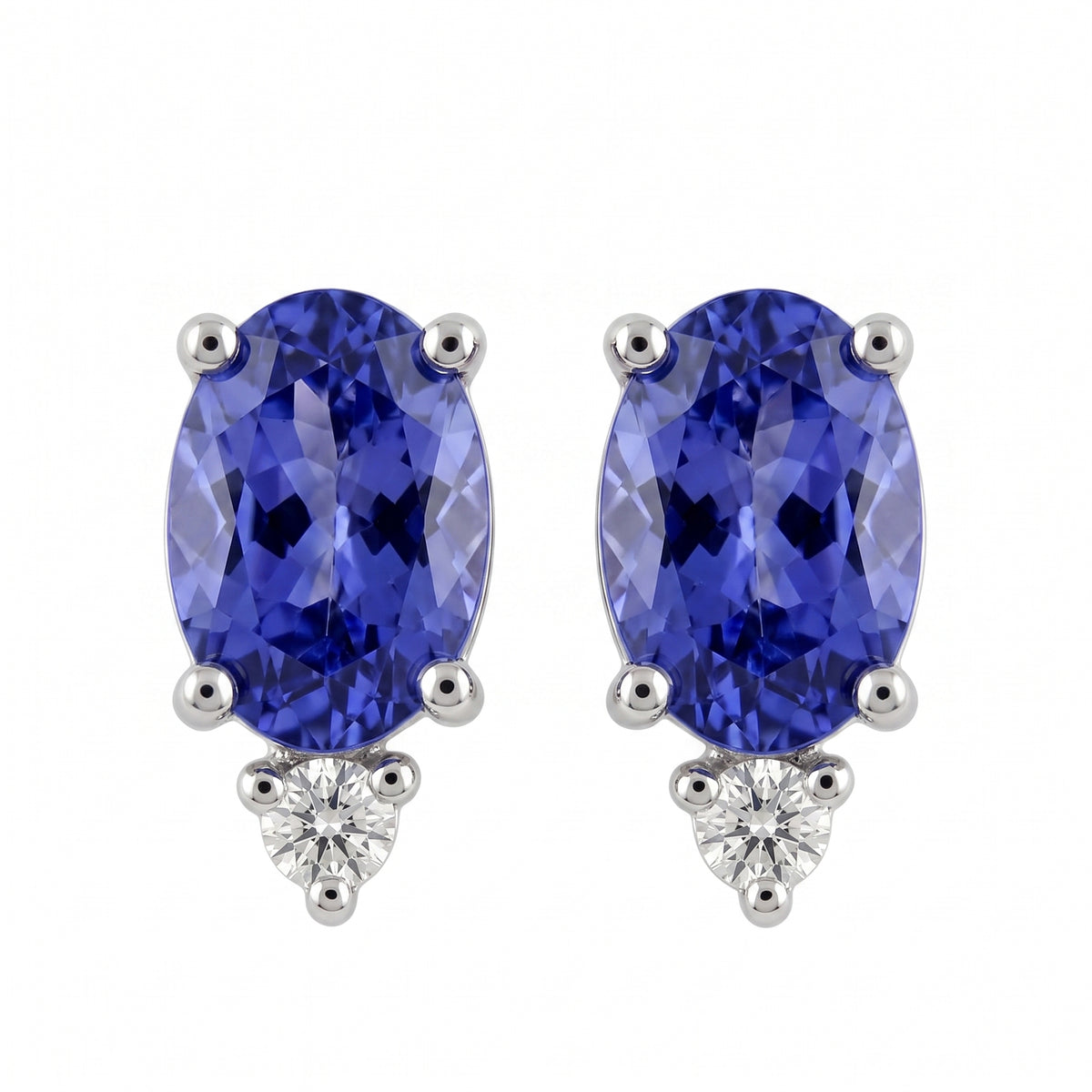 14k white gold seven by five millimetre oval tanzanite and round diamond post earrings, white background