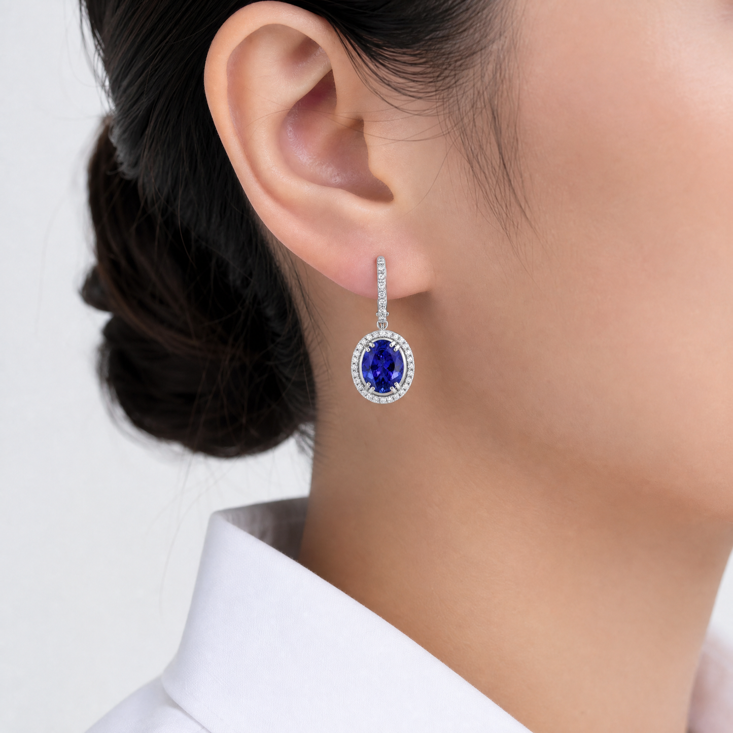 ZETE0582W model shot - oval tanzanite and diamond halo drop earring worn on ear